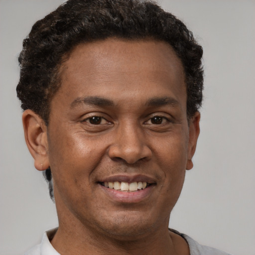 Joyful latino adult male with short  brown hair and brown eyes