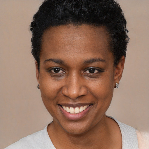 Joyful black young-adult female with short  black hair and brown eyes