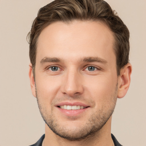 Joyful white young-adult male with short  brown hair and grey eyes