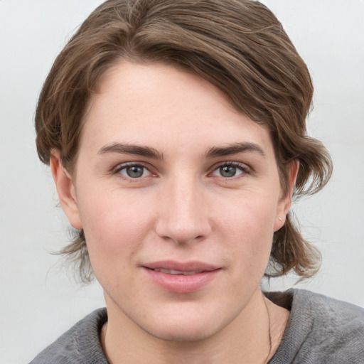 Joyful white young-adult female with medium  brown hair and grey eyes