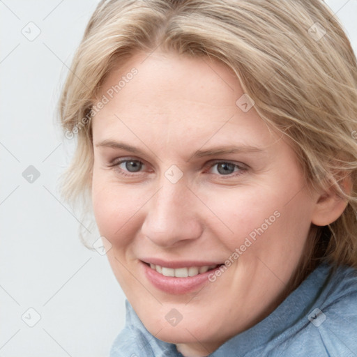 Joyful white young-adult female with medium  brown hair and blue eyes