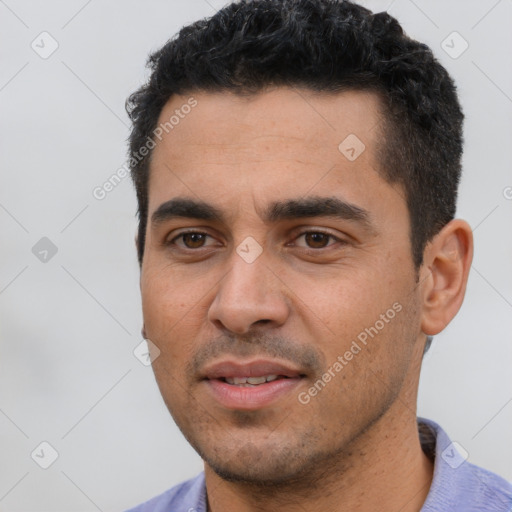 Joyful latino young-adult male with short  black hair and brown eyes