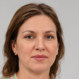 Joyful white adult female with medium  brown hair and green eyes