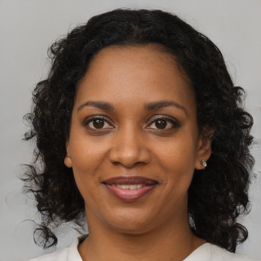 Joyful black young-adult female with medium  brown hair and brown eyes