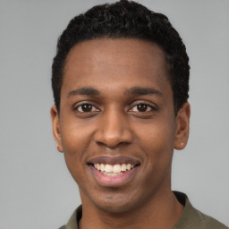 Joyful black young-adult male with short  black hair and brown eyes