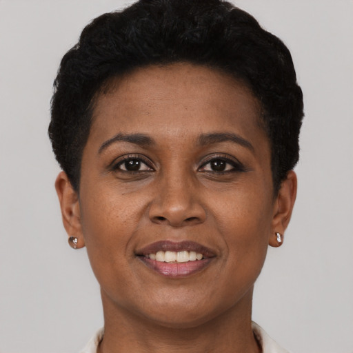 Joyful black young-adult female with short  brown hair and brown eyes