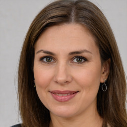 Joyful white adult female with long  brown hair and brown eyes