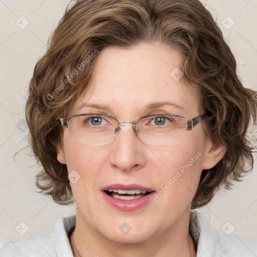 Joyful white adult female with medium  brown hair and blue eyes