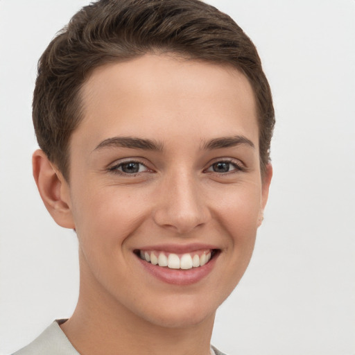 Joyful white young-adult female with short  brown hair and grey eyes