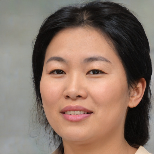 Joyful asian young-adult female with medium  brown hair and brown eyes