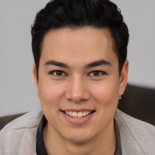 Joyful latino young-adult male with short  brown hair and brown eyes