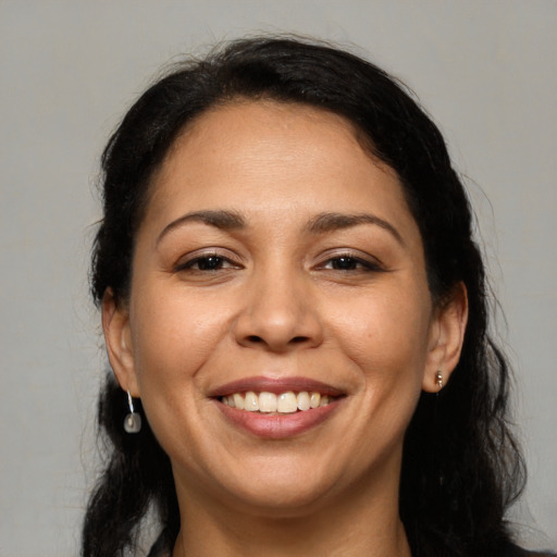 Joyful latino adult female with medium  brown hair and brown eyes