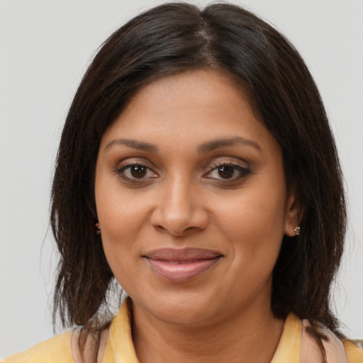Joyful black young-adult female with long  brown hair and brown eyes