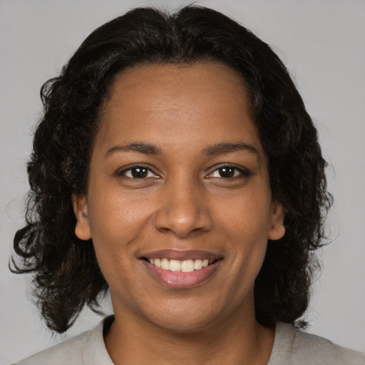 Joyful black young-adult female with medium  brown hair and brown eyes