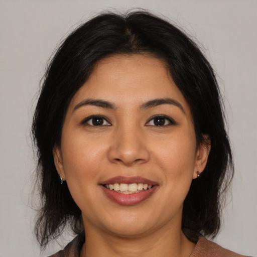 Joyful latino young-adult female with medium  brown hair and brown eyes