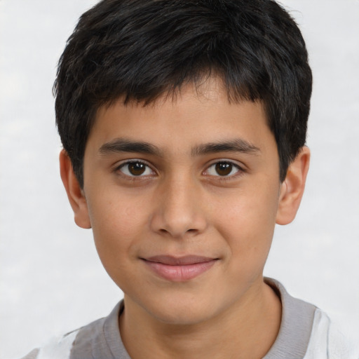Joyful latino child male with short  brown hair and brown eyes