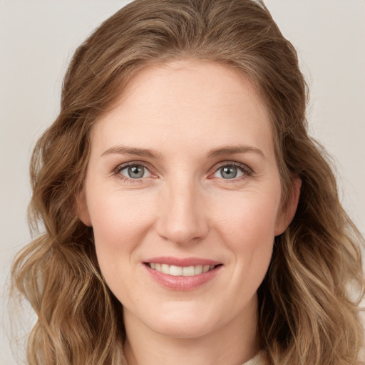 Joyful white young-adult female with long  brown hair and blue eyes