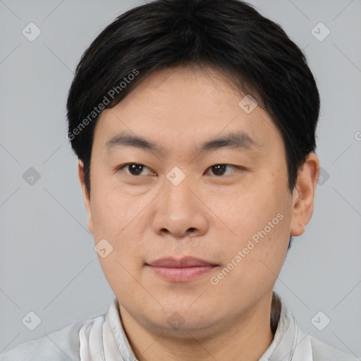 Joyful asian young-adult male with short  brown hair and brown eyes