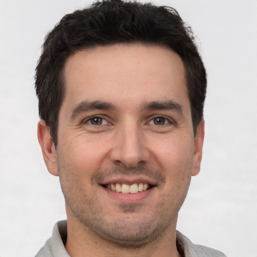 Joyful white young-adult male with short  brown hair and brown eyes