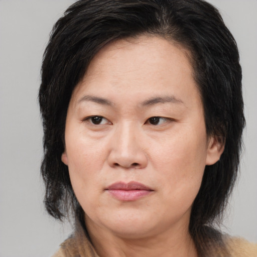 Joyful asian adult female with medium  brown hair and brown eyes