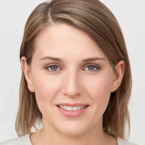 Joyful white young-adult female with medium  brown hair and grey eyes