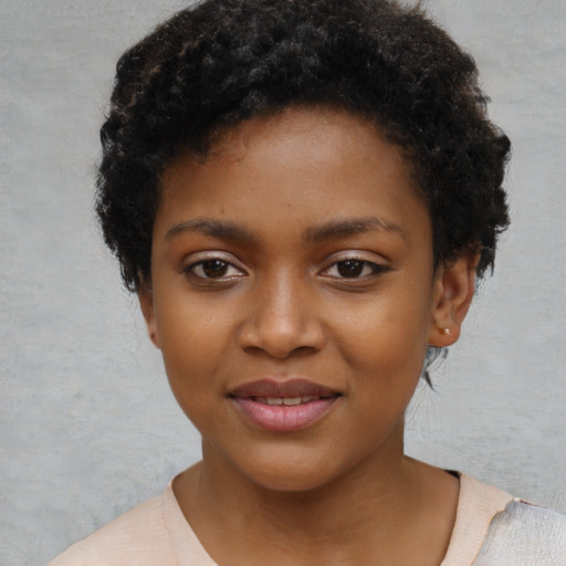 Joyful black child female with short  black hair and brown eyes