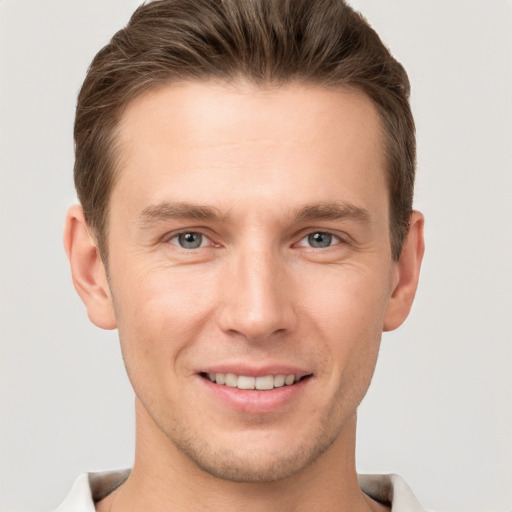 Joyful white young-adult male with short  brown hair and grey eyes