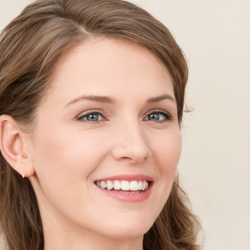 Joyful white young-adult female with long  brown hair and blue eyes