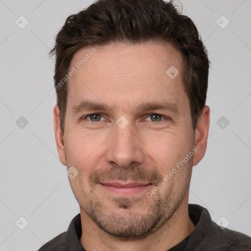 Joyful white adult male with short  brown hair and grey eyes