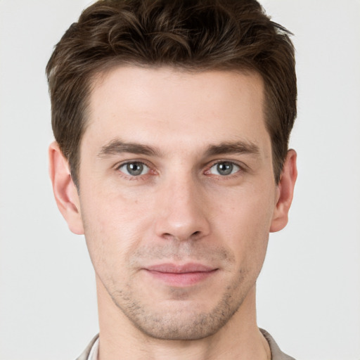 Joyful white young-adult male with short  brown hair and grey eyes