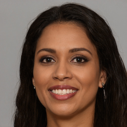 Joyful latino young-adult female with long  brown hair and brown eyes