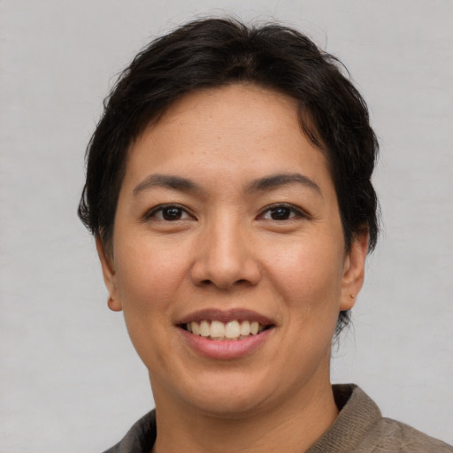 Joyful asian adult female with short  brown hair and brown eyes