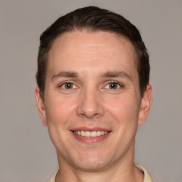 Joyful white adult male with short  brown hair and grey eyes