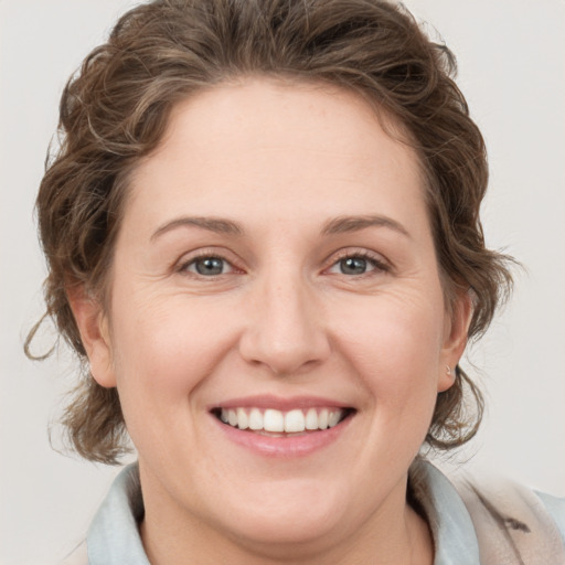 Joyful white young-adult female with medium  brown hair and blue eyes