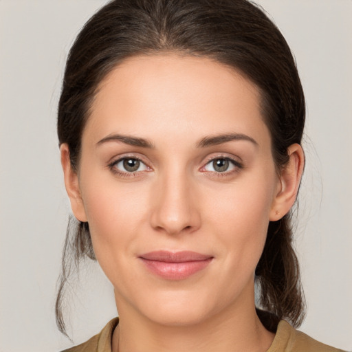 Joyful white young-adult female with medium  brown hair and grey eyes