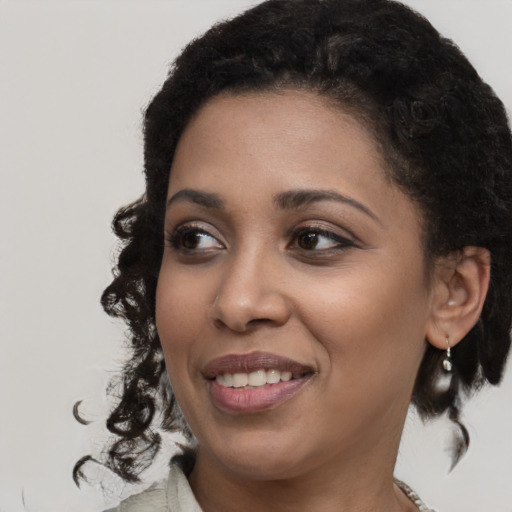 Joyful black young-adult female with medium  black hair and brown eyes