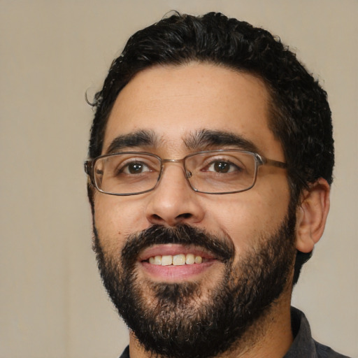 Joyful latino young-adult male with short  black hair and brown eyes