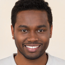 Joyful black young-adult male with short  brown hair and brown eyes