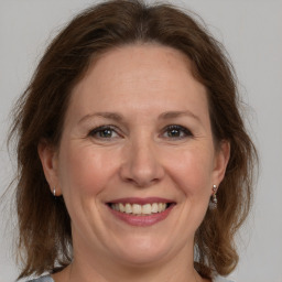 Joyful white adult female with medium  brown hair and grey eyes