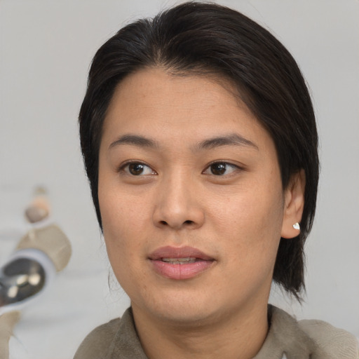 Joyful asian young-adult female with medium  brown hair and brown eyes