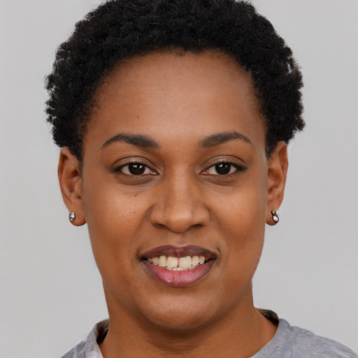 Joyful black young-adult female with short  black hair and brown eyes