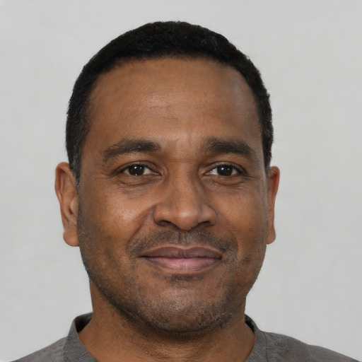 Joyful black adult male with short  black hair and brown eyes