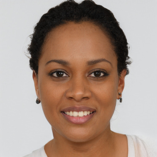 Joyful black young-adult female with short  black hair and brown eyes