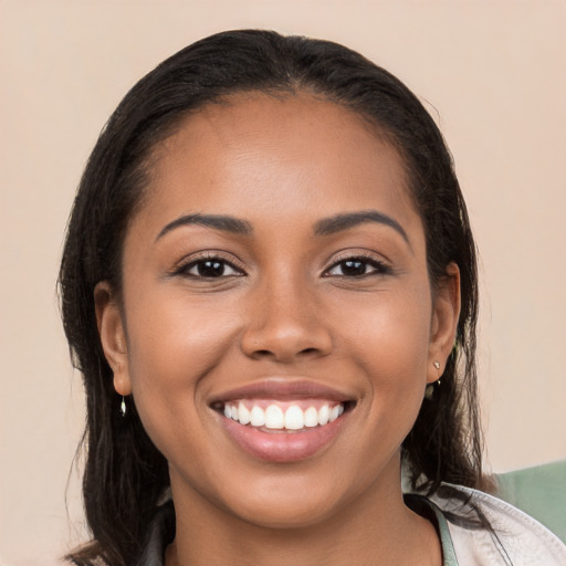 Joyful latino young-adult female with long  brown hair and brown eyes