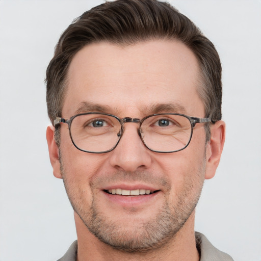 Joyful white adult male with short  brown hair and grey eyes