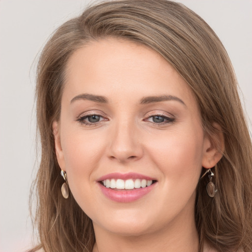 Joyful white young-adult female with long  brown hair and grey eyes