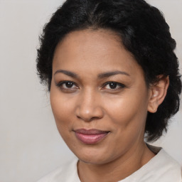 Joyful black adult female with medium  brown hair and brown eyes