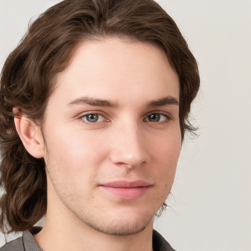 Joyful white young-adult male with medium  brown hair and grey eyes