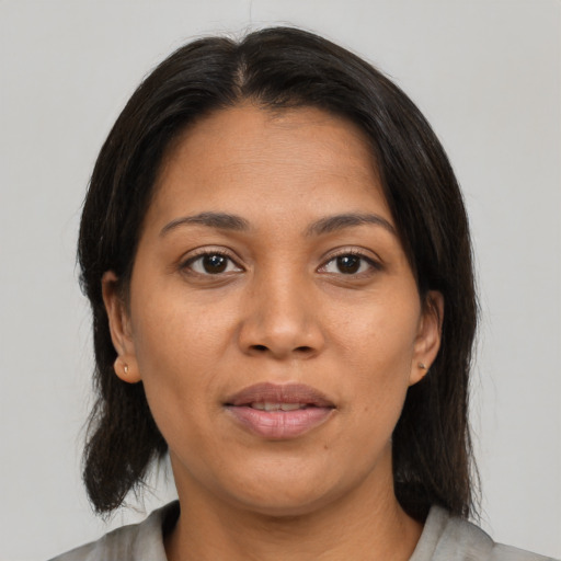 Joyful latino young-adult female with medium  brown hair and brown eyes