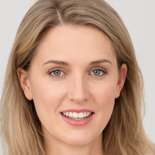 Joyful white young-adult female with long  brown hair and blue eyes